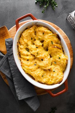 Patates graten. Koyu masada taze pişmiş peynirli patates güveci, üst manzara, yakın çekim..