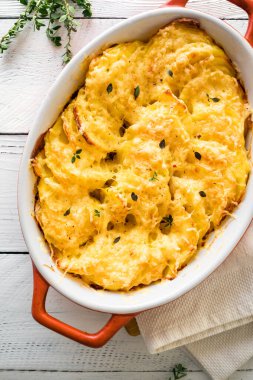 Patates graten. Taze pişmiş peynirli patates güveci beyaz ahşap masada, üst manzara, kapat..