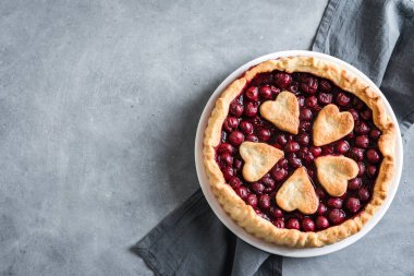 Gri taş zemin üzerinde ev yapımı vişneli turta, üst görünüm, kopyalama alanı.