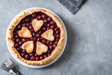 Gri taş zemin üzerinde ev yapımı vişneli turta, üst görünüm, kopyalama alanı.