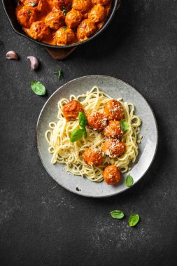Köfteli spagetti makarna, domates sosu rendelenmiş peynir ve taze fesleğen. Sağlıklı ev yapımı İtalyan makarnası..
