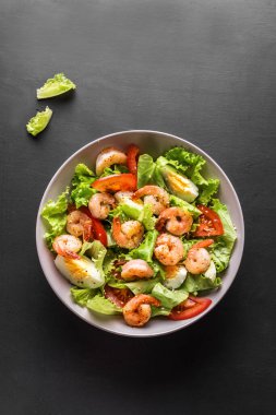 Karides salatası. Siyah arka planda deniz ürünleri Sezar Salatası, üst manzara, kopyalama alanı.