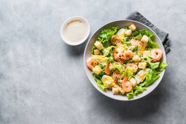 Karides salatası. Gri taş zemin üzerinde deniz ürünleri Sezar Salatası, üst görünüm, kopyalama alanı.
