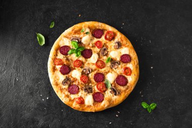 Pepperonili Supreme Pizza, mantarlı ve mozzarella peynirli siyah masa, üst manzara, kopyalama alanı. Taze ev yapımı pizza..