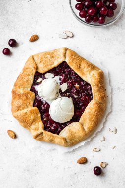 Beyaz üzerine badem ve vanilyalı dondurma sergilenen Cherry Galette, üst manzara, kopyalama alanı. Ev yapımı sağlıklı tatlı - vişneli turta ya da Fransız galeti.
