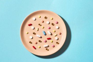 Tabakta yiyecek olarak çeşitli vitamin hapları ve takviyeler var. Besin takviyesi konsepti. İlaç alıyorum. Yemek yerine hap..