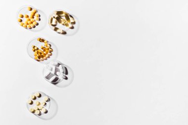 Beyaz arka planda vitamin kapsülleri, üst görünüm, kopyalama alanı. Besin takviyeleri: balık yağı, omega 3, omega 6, omega 9, A vitamini, D3, E, B, kalsiyum.