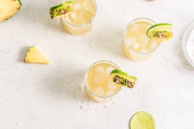 Ananaslı Margarita kokteyli. Yaz ayyaşı, tekila ile ferahlatıcı içecek, tuzlu bardakta ananas, üst manzara..