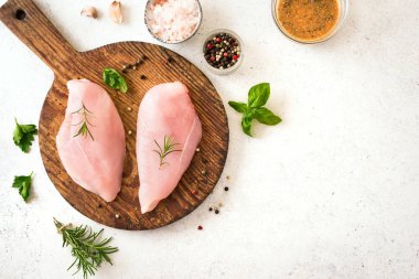 Tahta tahtada otlar ve baharatlarla taze çiğ tavuk göğsü filetosu, üst manzara, kopyalama alanı. Tavuk ya da hindi eti pişmeye hazır..