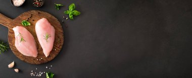 Tahta tahtada otlar ve baharatlarla taze çiğ tavuk göğsü fileto, kopyalama alanı. Tavuk ya da hindi eti pişmeye hazır..