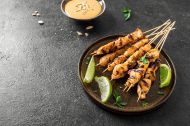 Limon ve fıstık sosuyla servis edilen ızgara tavuk şişleri, fotokopi alanı. Asya Tayland tarzı yemekler..