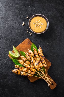 Limon ve fıstık sosuyla servis edilen ızgara tavuk şişleri, fotokopi alanı. Asya Tayland tarzı yemekler..