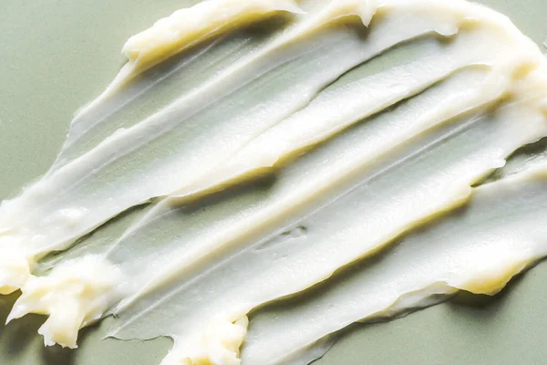 化粧品のクリームブラシの質感は 緑の背景にスムードアップ 閉じます グレーの表面にスキンケア製品の白い黄色のスウォッチ — ストック写真