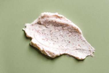 Yeşil arka planda doğal fırça örneği. Mikro kapsüllü krema. Şeftali ya da kahve lekesi..