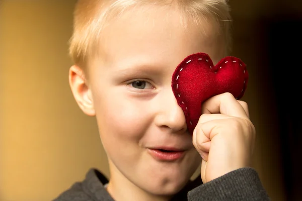 Kırmızı kalp ile mutlu bir çocuk — Stok fotoğraf