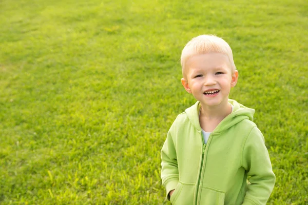 Niño feliz sobre hierba verde —  Fotos de Stock