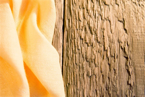 Yellow napkin on wooden background — Stock Photo, Image