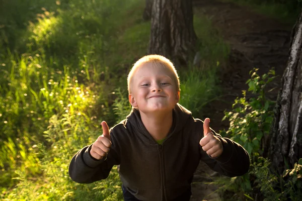 Child in forest, thumbs up — Stockfoto