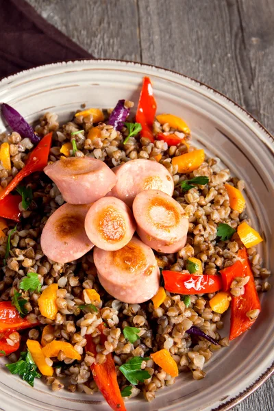 Buckwheat with sausages and vegetables — Stock Photo, Image