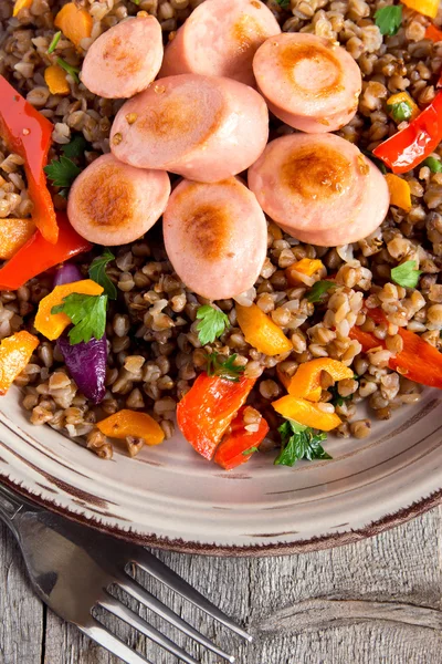 Buckwheat with sausages and vegetables — Stock Photo, Image