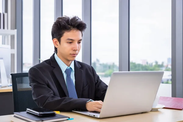 年轻的亚洲人坐在写字台前 用笔记本电脑工作 商人或工薪人员的生活 — 图库照片