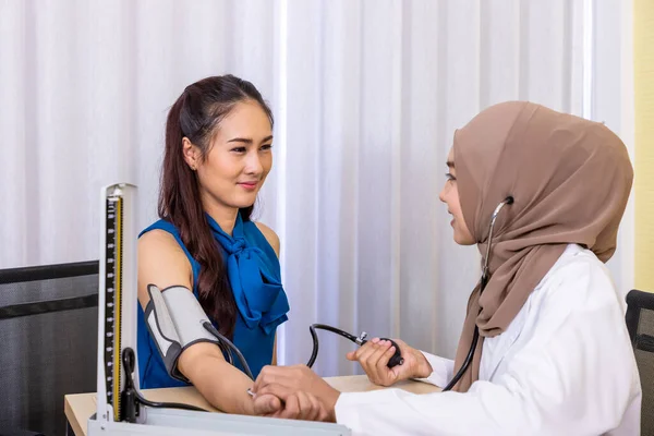 Mujer Musulmana Médica Examinando Midiendo Presión Arterial Paciente Sentada Silla —  Fotos de Stock