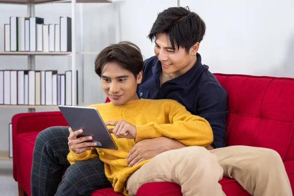 Pareja Gay Asiática Sentada Sofá Usando Una Tableta Navegando Por Fotos de stock libres de derechos