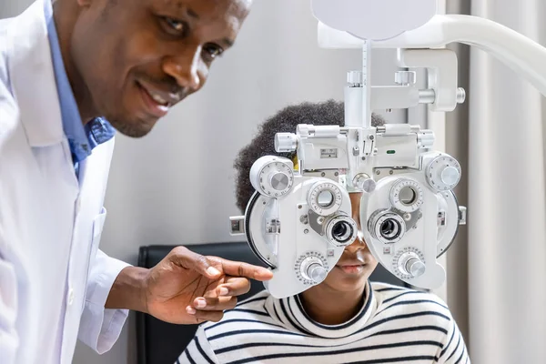 Menina Jovem Africana Fazendo Exame Verificação Olho Usando Phoropter Clínica Fotografia De Stock