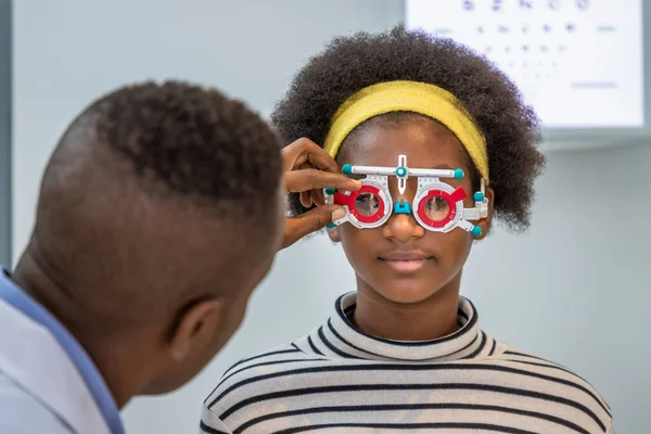Chica Joven Africana Haciendo Examen Revisión Ojos Con Hombre Optometrista Imágenes de stock libres de derechos