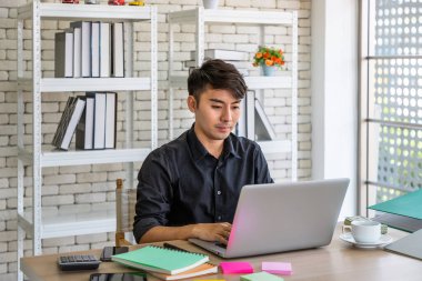 Genç Asyalı iş adamı yemek odasında dizüstü bilgisayarla çalışıyor, meslektaşıyla online toplantı yapıyor..