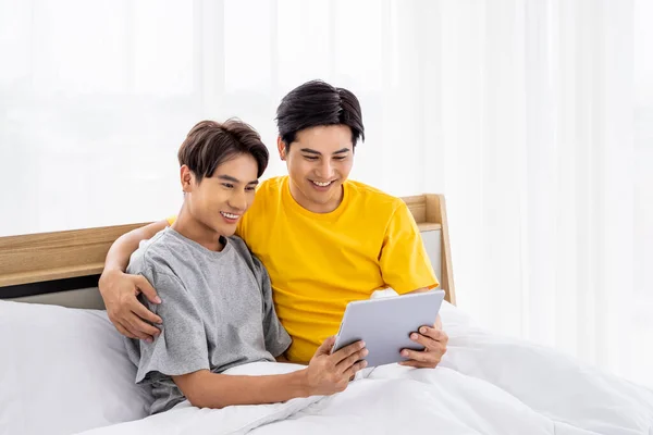 幸せなアジアの同性愛者のカップルが一緒にタブレットを使用して白いベッドに座って Lgbtの概念 — ストック写真