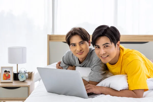 幸せなアジアの同性愛者のカップルが一緒にラップトップコンピュータを使用して白いベッドに横たわって Lgbtの概念 — ストック写真