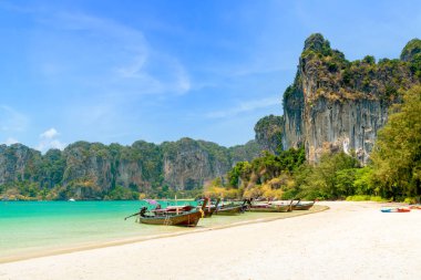 Railay plajı batıda egzotik kireç taşı dağları ve uzun kuyruklu ahşap turist teknesi, Krabi, Tayland