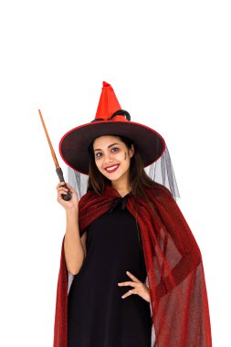 Kırmızı pelerinli cadı kostümü giymiş Asyalı bir kadın beyaz arka planda sihirli değnek tutuyor ve kameraya bakıyor.