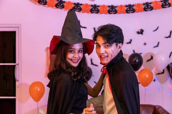 若い幸せなアジアの人々は ハロウィンの衣装 吸血鬼と魔女を身に着けて パーティーで踊ります カメラを見ると — ストック写真