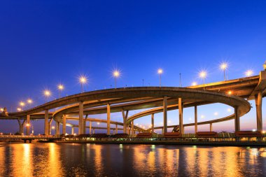 alacakaranlıkta Bangkok'ta nehrin kıyısında expressway eğrisi 