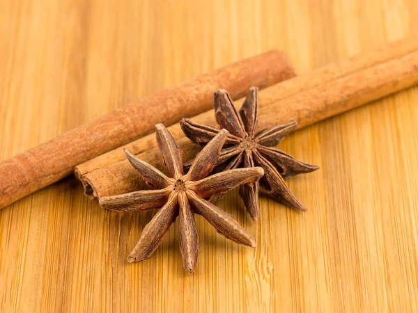 Anise stars and cinnamon stick on wooden board — Stock Photo, Image
