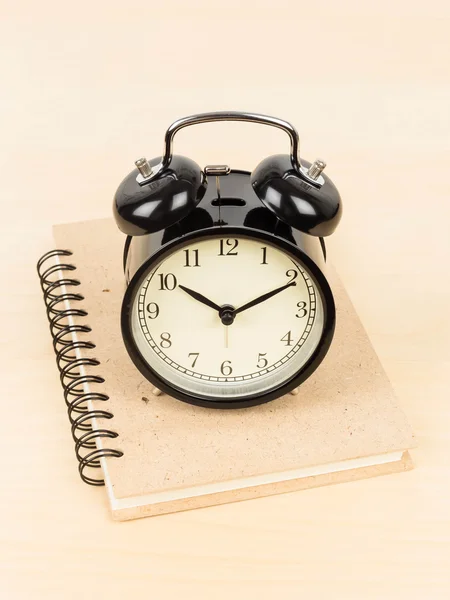 Alarm clock on ring binder book or notebook — Stock Photo, Image