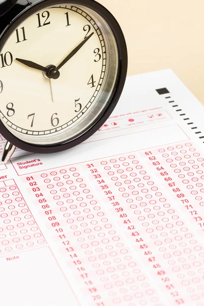 Answer sheet with alarm clock — Stock Photo, Image