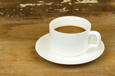 Kahve fincanı eski ahşap masada.