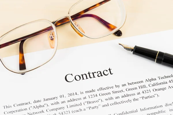 Geschäftsvertragsdokument auf cremefarbenem Papier mit Stift und Gla — Stockfoto
