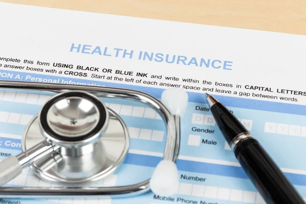 Modulo di domanda di assicurazione sanitaria con penna e stetoscopio conce — Foto Stock