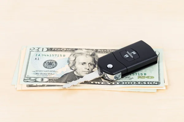 Современный ключ от машины и долларовая купюра на деревянном фоне — стоковое фото