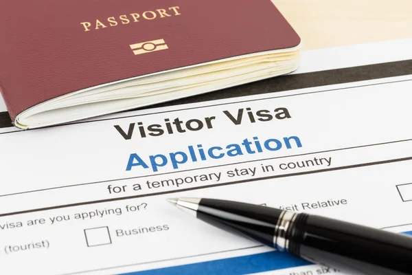 Formulario de solicitud de visado con pasaporte y pluma — Foto de Stock