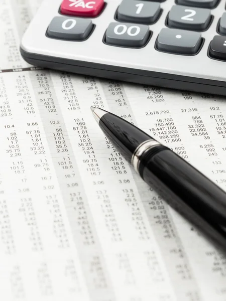 Ручка і калькулятор відпочинок на деталі фондової ціни фінансова газета — стокове фото