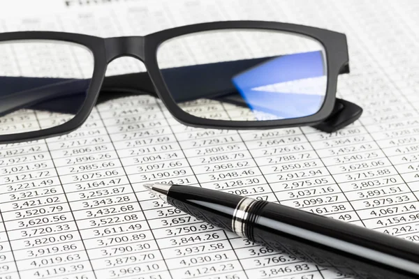 Analyse du rapport financier avec stylo et lunettes — Photo