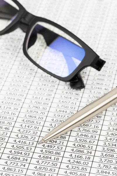 Stylo et lunettes reposent sur le détail du cours de l'action journal financier — Photo