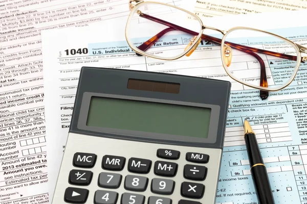 Formulario de impuestos con pluma, calculadora, y el concepto de impuestos gafas — Foto de Stock
