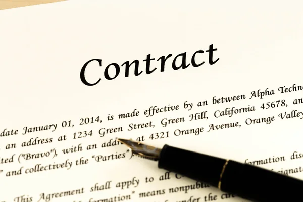Document de contrat d'affaires sur papier couleur crème avec stylo et gla — Photo