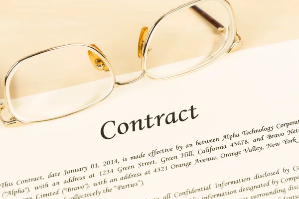 Business contract document on cream color paper with glasses — Stock Photo, Image